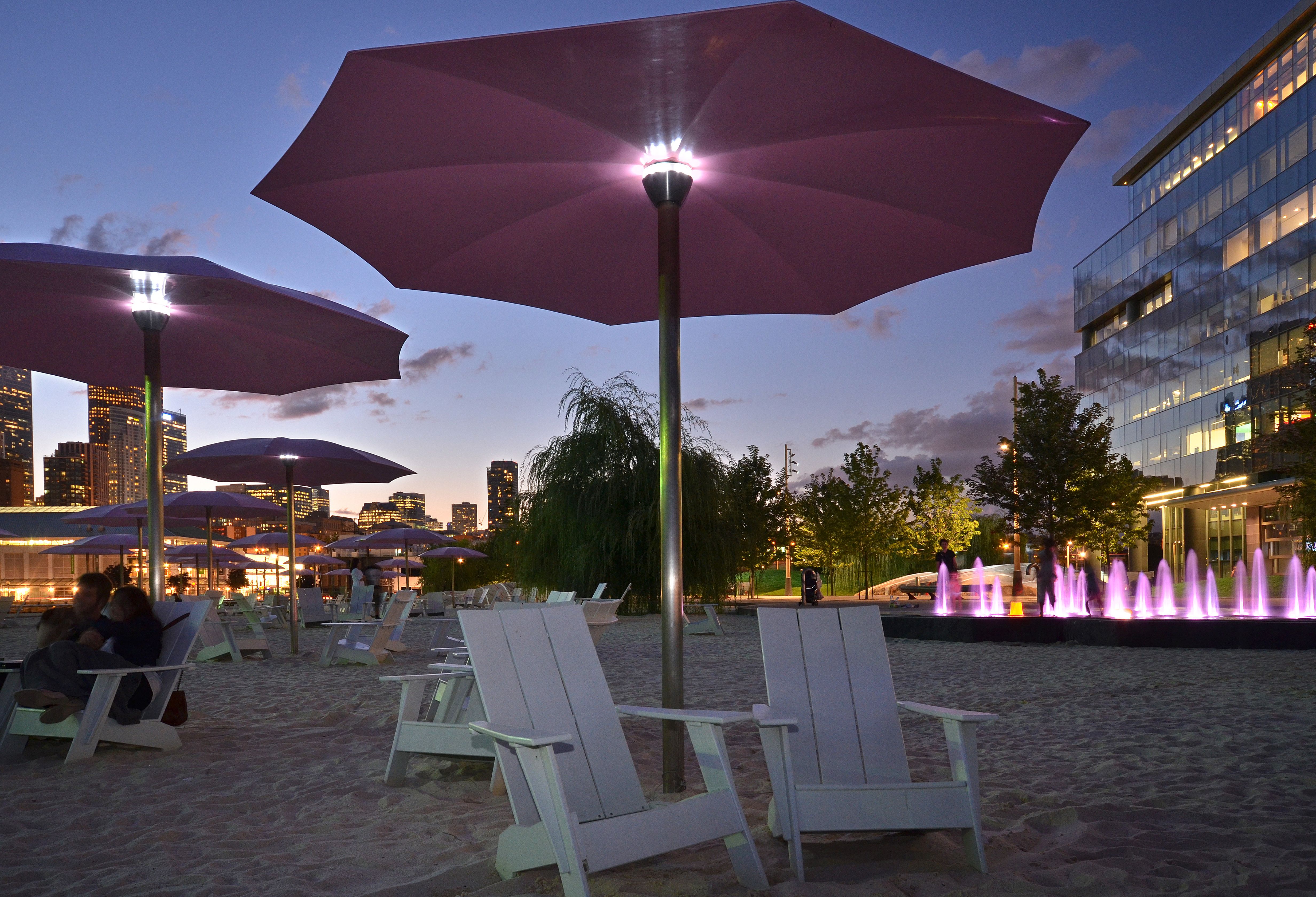 The pink umbrellas, white Muskoka chairs and sandy beach at Canada's Sugar Beach