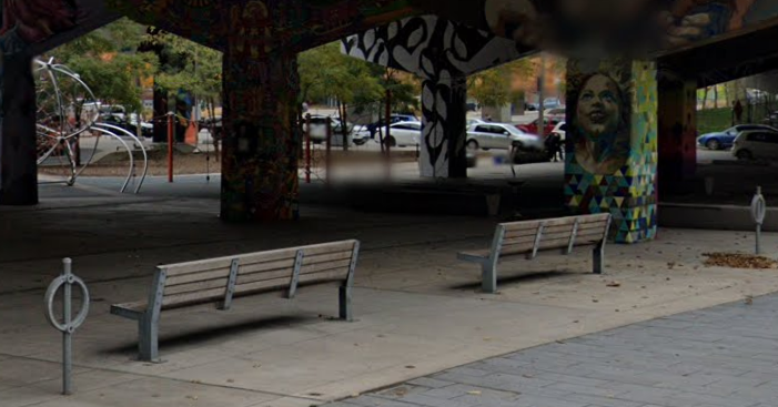 a photo showing two street benches next to a nearby park
