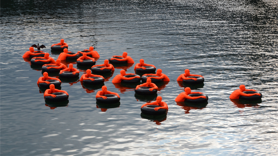 Safety Orange Swimmers floating art installation.