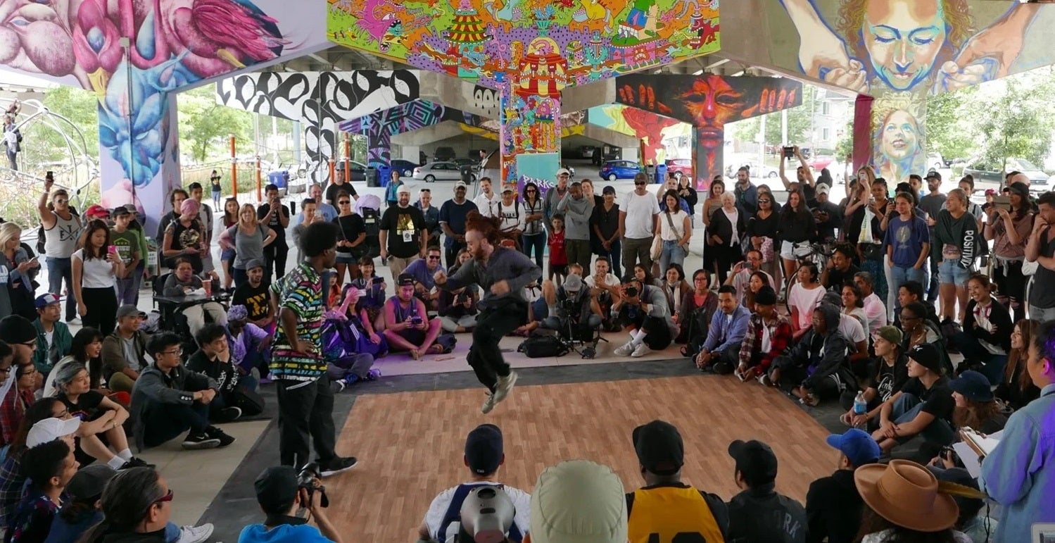 a crowd of people watching a street performer at Underpass Park