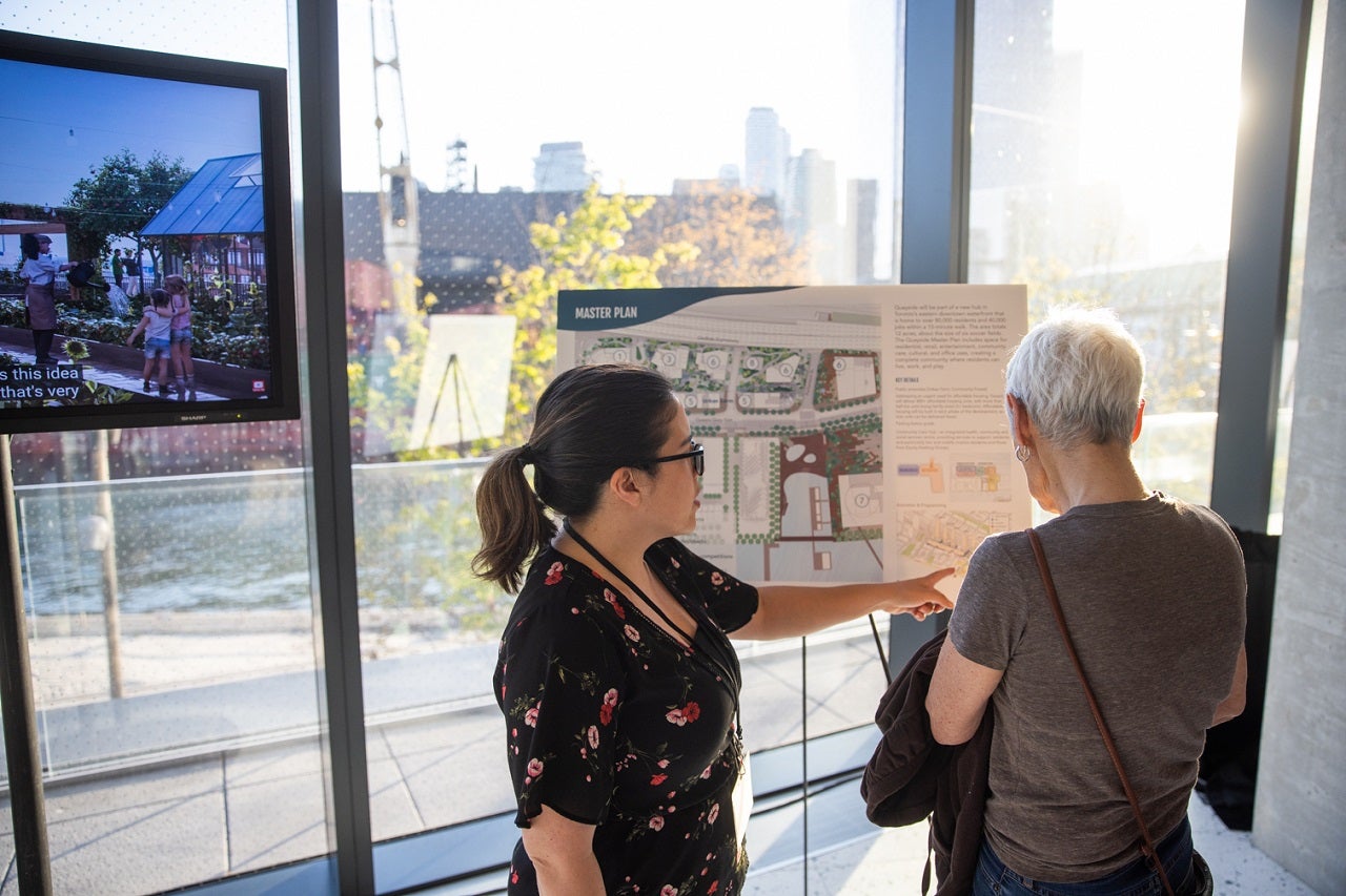 Two people discussing display boards at a public meeting. 