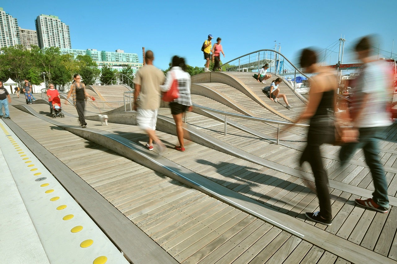 people walking next to the curvy wooden Simcoe WaveDeck
