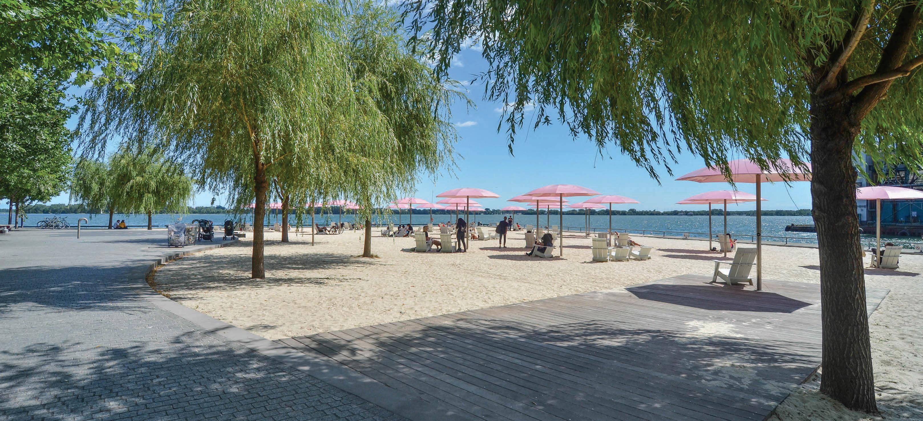 an urban beach with pink umbrellas and willow trees