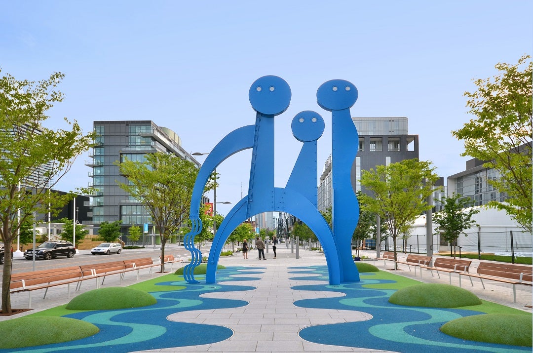 Three very large, curvy blue art structures on a public street 