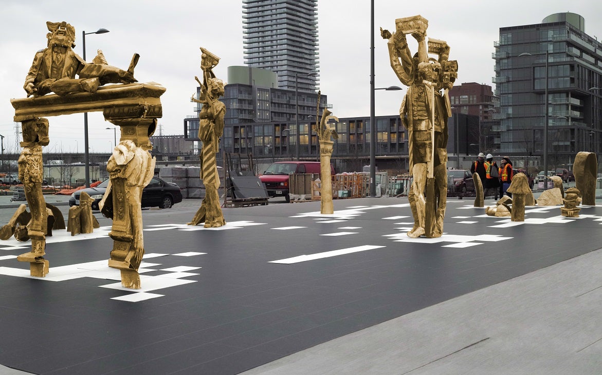 Bronze statues being installed on a street as public art