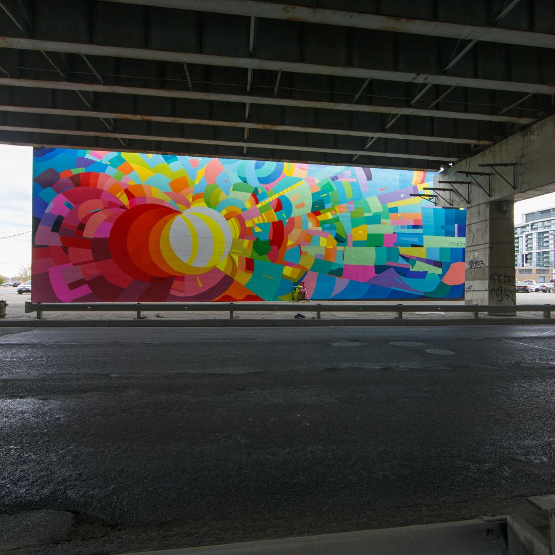 a mural on the side of a building next to the Gardiner Expressway and Lake Shore Boulevard East