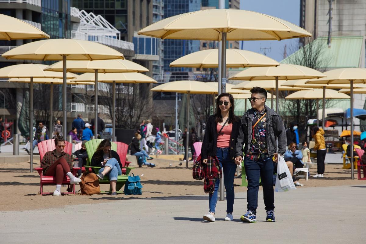 People strolling through a busy urban beach.