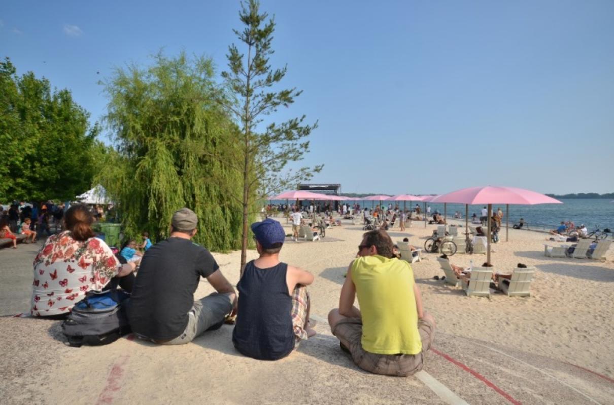 Festival-goers sit on the rocky outcropping at Canada's Sugar Beach