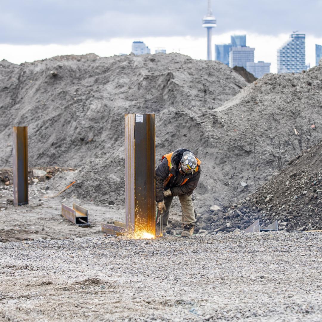 a construction worker on a project site with the Toronto skyline in the background