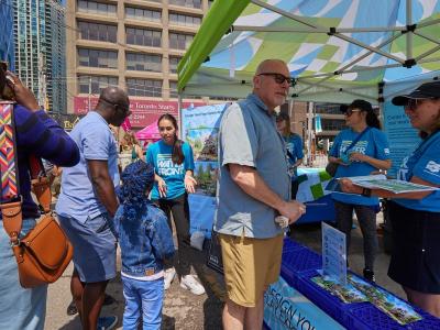 people speaking to staff at a waterfront event