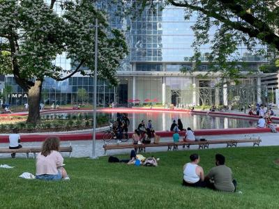 groups of people spread out on the lawn next to a red heart shaped park pond