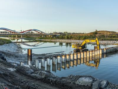 An excavator removing part of the north plug of a river.