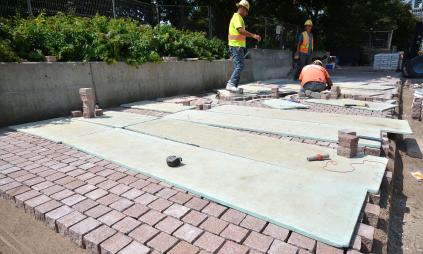 construction crews installing granite pavers